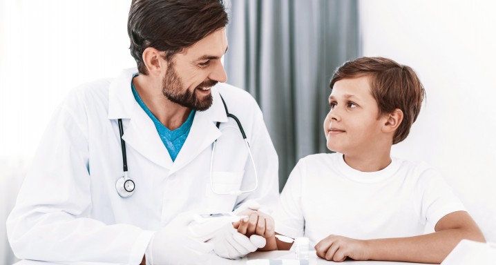 Doctor Taking Blood Sample from Boy's Finger.